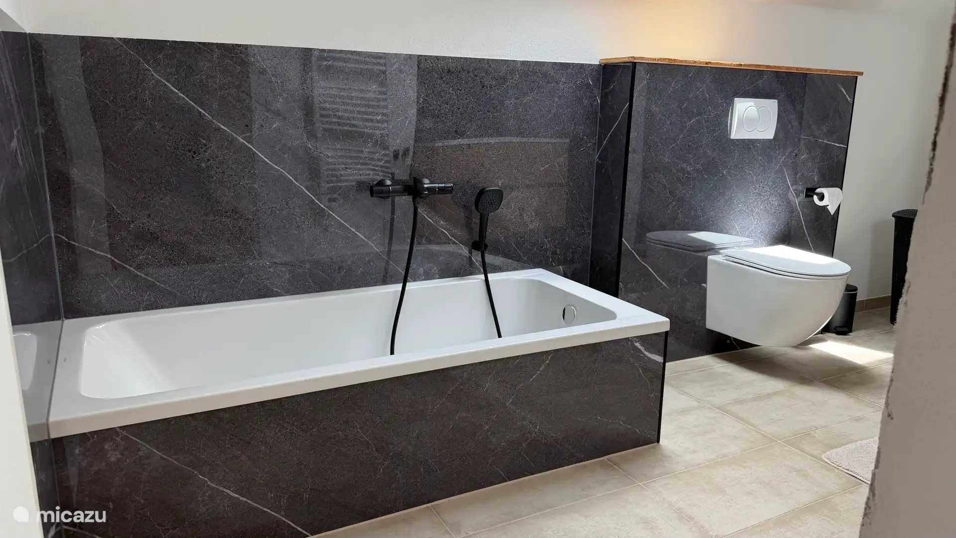 De nieuwe badkamer met ligbad, toilet, ruime doucheruimte, dubbele wastafel, vloerverwarming, nieuw ruimer Velux dakraam 