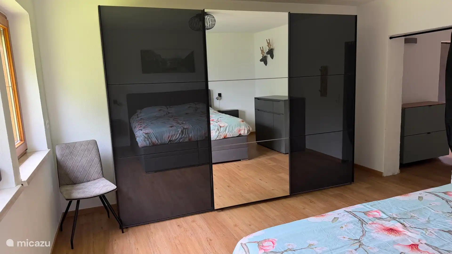 Op de begane grond is een grote slaapkamer met ruime boxspring van 180 x 200 en echtes hoog. Royale schuifdeuren kledingkast. Vanuit de slaapkamer heb je zicht op de tuin en de Julische Alpen 