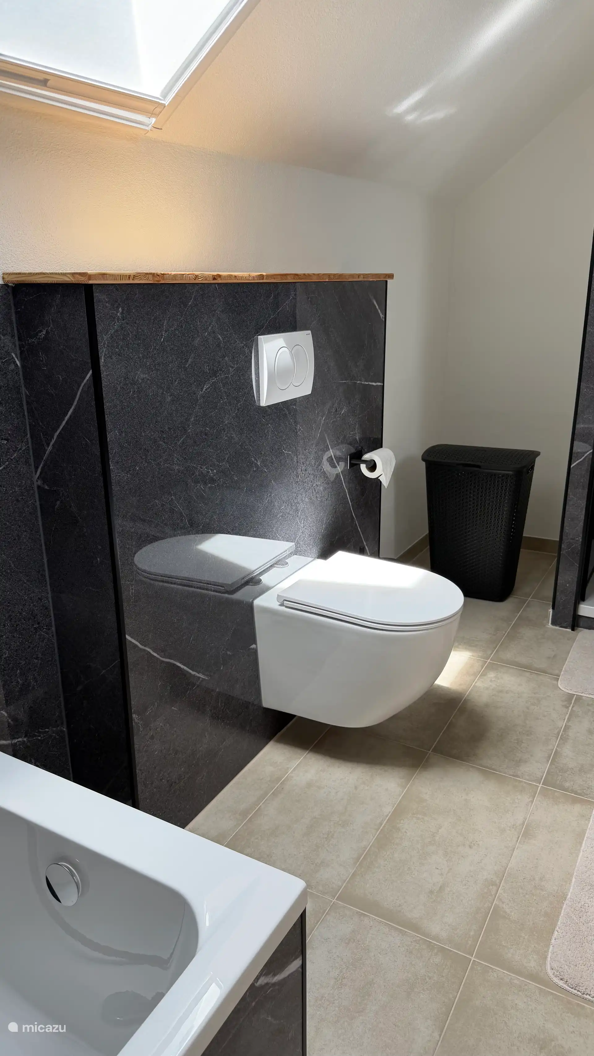 De nieuwe badkamer met ligbad, toilet, ruime doucheruimte, dubbele wastafel, vloerverwarming, nieuw ruimer Velux dakraam