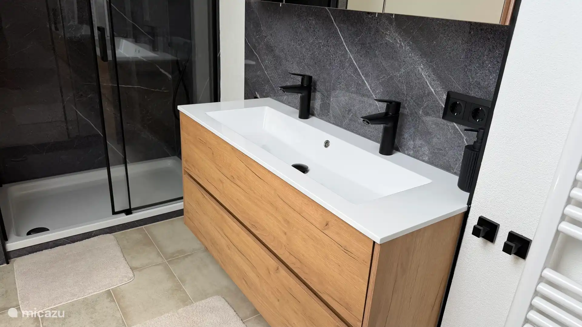 De nieuwe badkamer met ligbad, toilet, ruime doucheruimte, dubbele wastafel, vloerverwarming, nieuw ruimer Velux dakraam