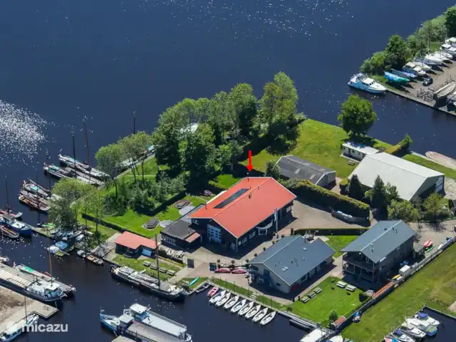 Villa de vacances spacieuse sur le lac frison | Pays-Bas, Frise, Eernewoude - villa Le bâtiment (une ancienne école de surf) dans lequel se trouve la maison de vacances. avec terrasses et jardins privés sur l'eau