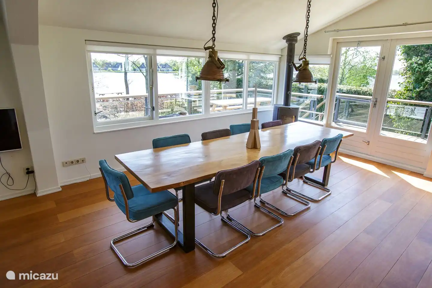 Cozy large dining table with a view of the water, next to the wood stove.
