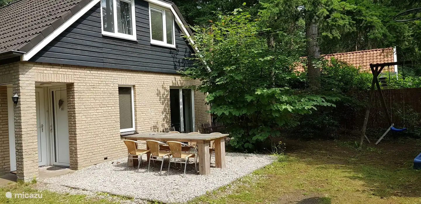 mehrere Sitzgelegenheiten mit vielen Stühlen, sowohl unter der Veranda als auch im Garten