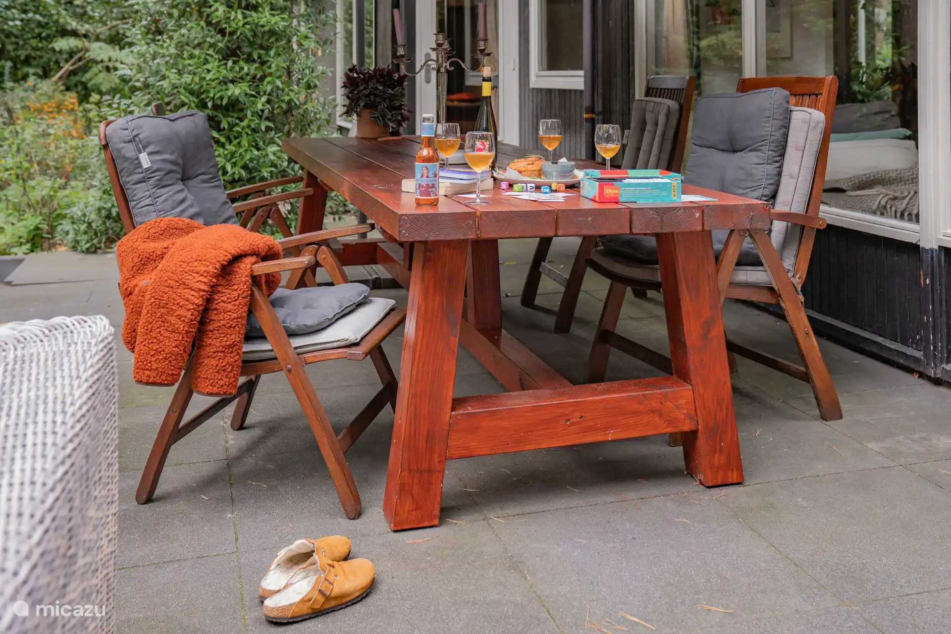 La table du jardin est sous un parasol sur la terrasse