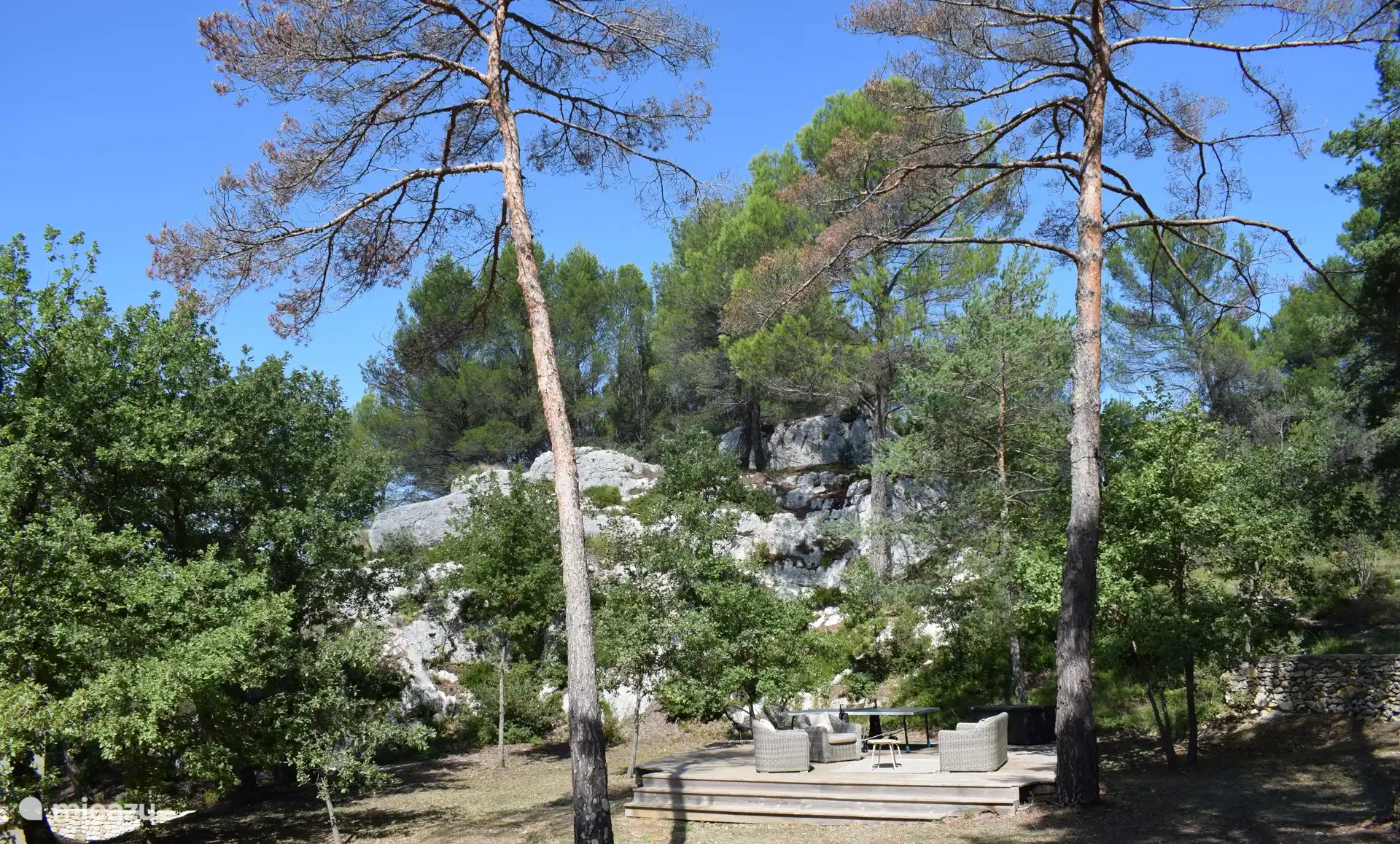 Holzterrasse mit Tischtennisplatte mitten zwischen den Felsen und der Natur