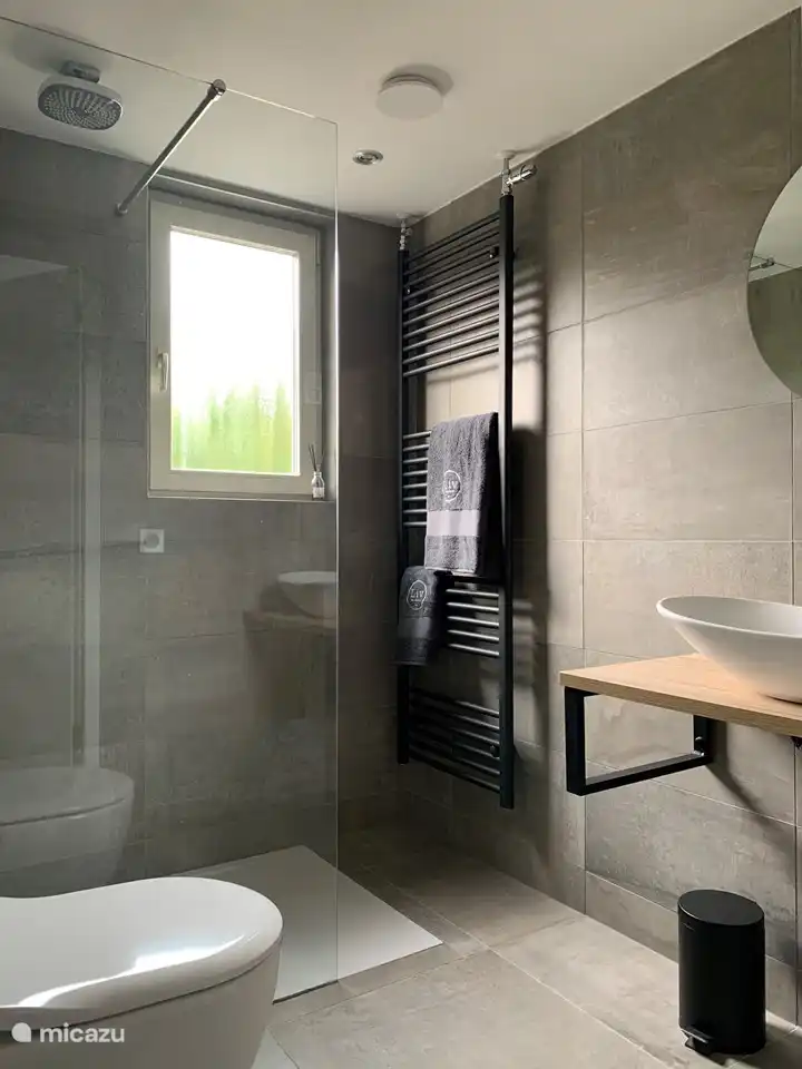 Das Badezimmer mit ebenerdiger Regendusche.