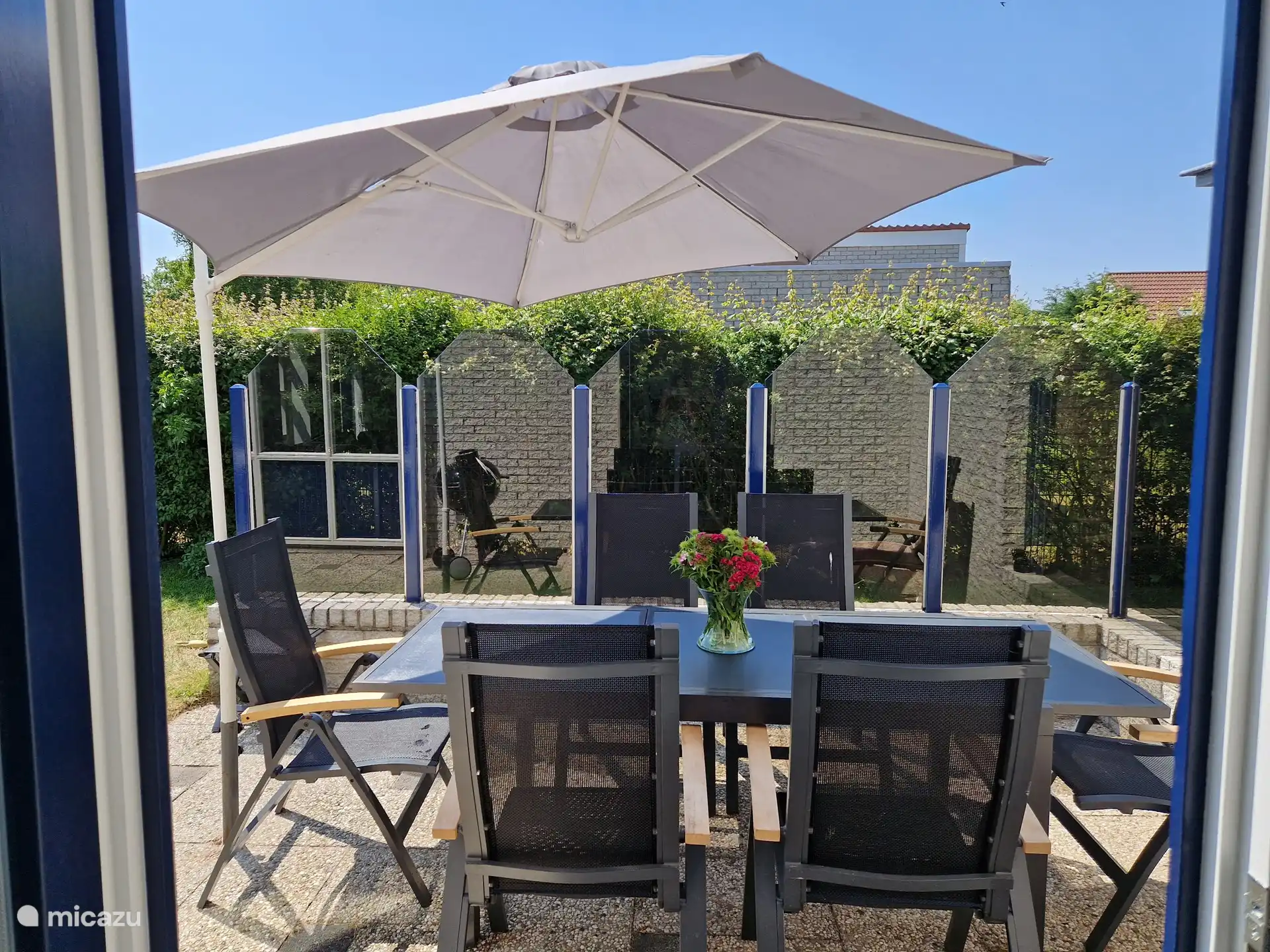 Genießen Sie unter dem Sonnenschirm auf der schönen Terrasse.