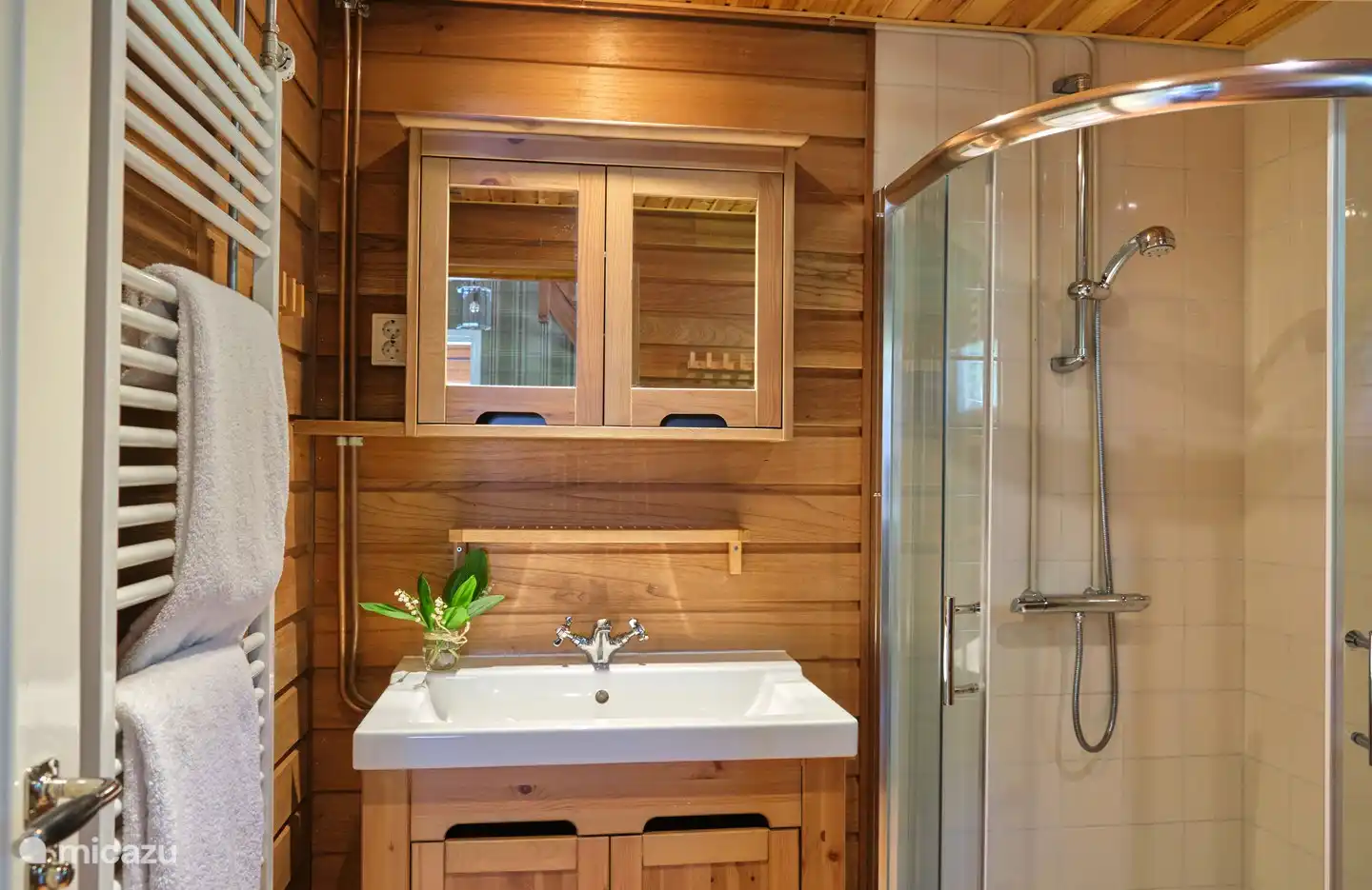 Das Badezimmer mit Dusche ist mit einer Miele Waschmaschine ausgestattet