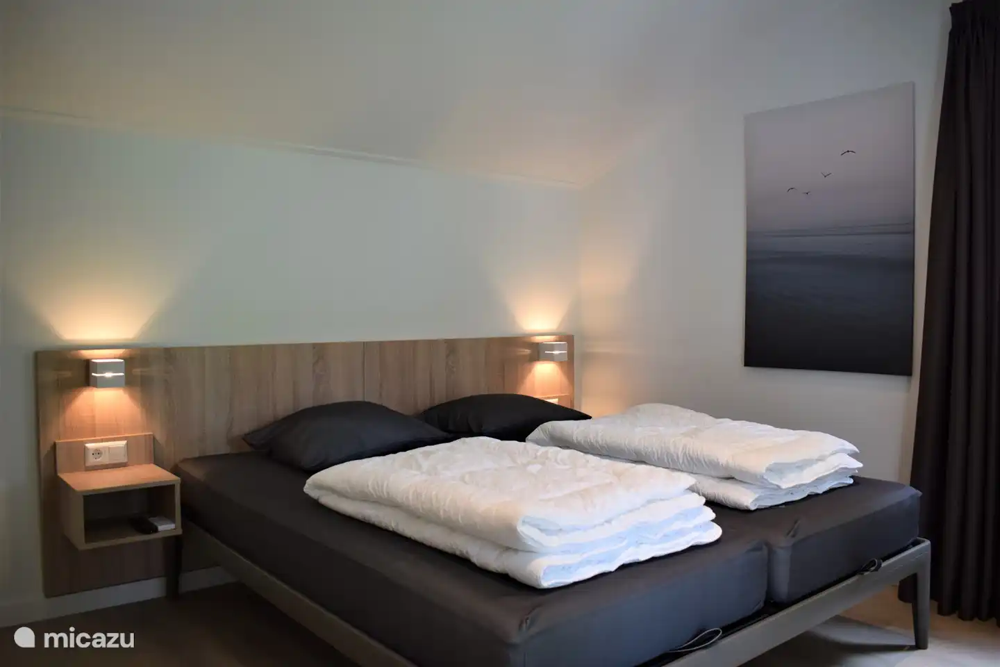 Schlafzimmer im Erdgeschoss mit 2 Einzelbetten, luxuriösem Kopfteil, TV und Terrassentüren zur Terrasse mit Baldachin