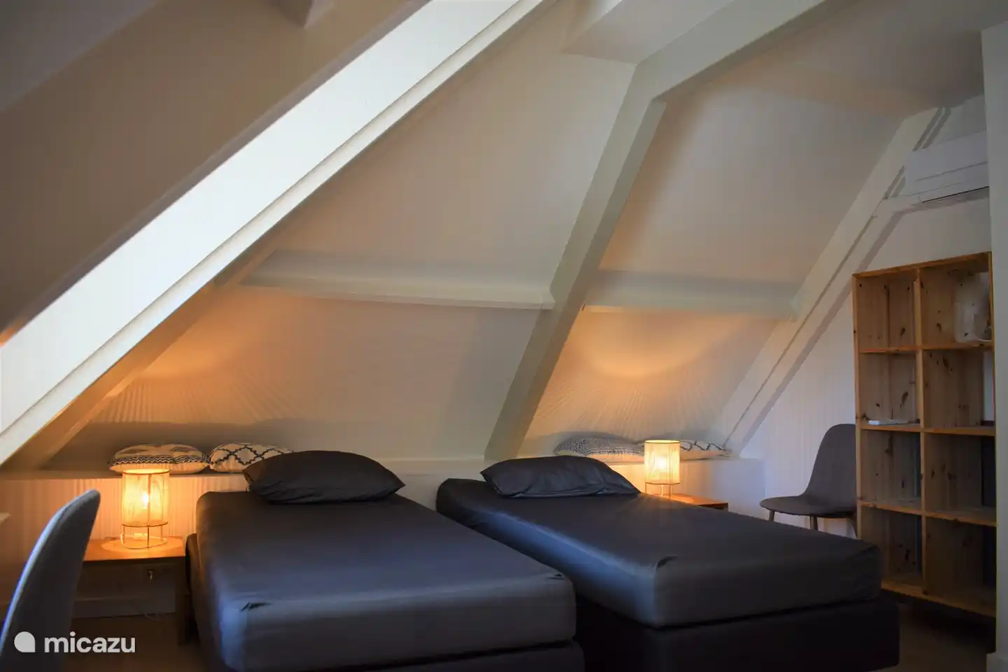 Schlafzimmer 1 auf der Etage mit 2 Einzelbetten und einer Sitzecke und einem Arbeitstisch