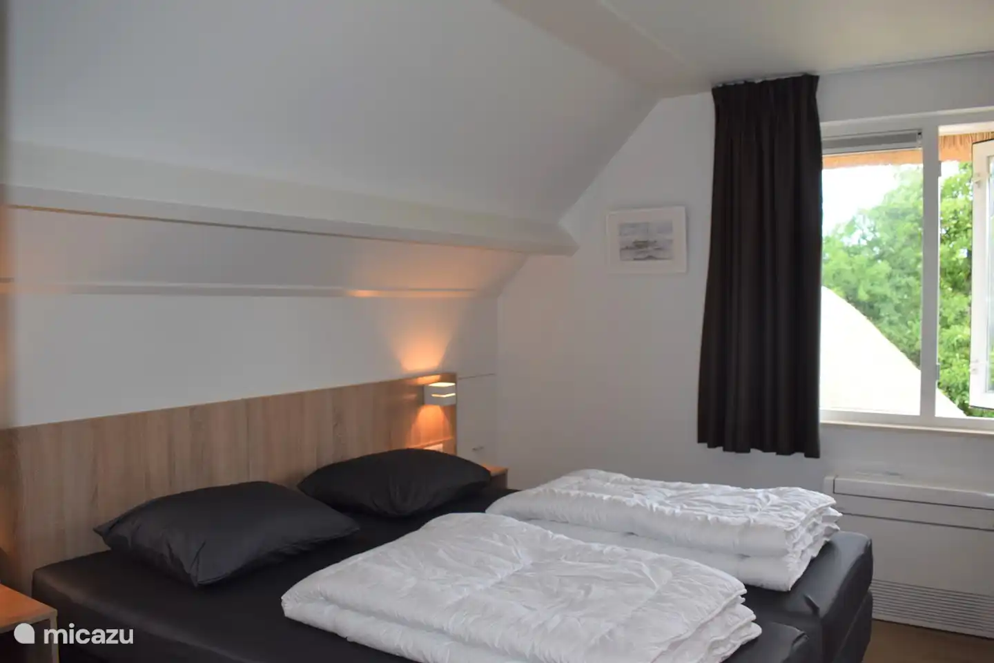 Schlafzimmer 2 im Obergeschoss mit 2 Einzelbetten, Kopfteil und begehbarem Kleiderschrank und schönem Blick auf die Wiese mit Pferden