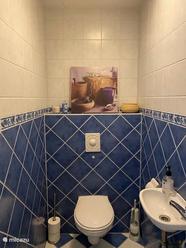 Spacious toilet with all toilet supplies and accessories.