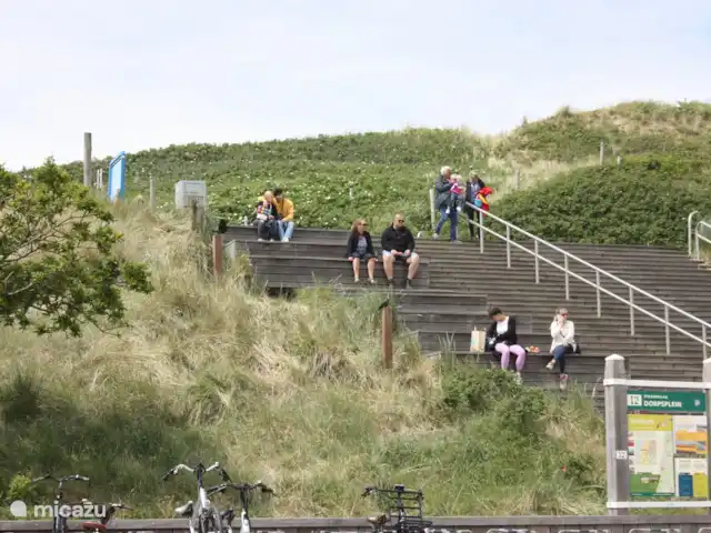 Appartement Plage Retour à la Côte | Pays-Bas, Hollande du Nord, Callantsoog - appartement De la terrasse du balcon couvert, vous pouvez voir l'entrée de la plage au Dorpsplein à une distance de 150 mètres. Des gens merveilleux qui regardent. Balayez le sable de vos pieds et dégustez une portion de frites ou de crème glacée, avec vue sur la Dorpsplein.