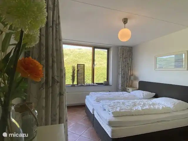 Appartement Plage Retour à la Côte | Pays-Bas, Hollande du Nord, Callantsoog - appartement Chambre avec un nouveau lit sommier Emma Sleeps 160x200 recouvert de 2 surmatelas et d'un choix d'oreillers fermes ou moelleux. Nouveaux rideaux et volet roulant occultant. Porte au balcon adjacent. Beaucoup d'espace de rangement et une tour de ventilation pour la fraîcheur. Vue sur les dunes !