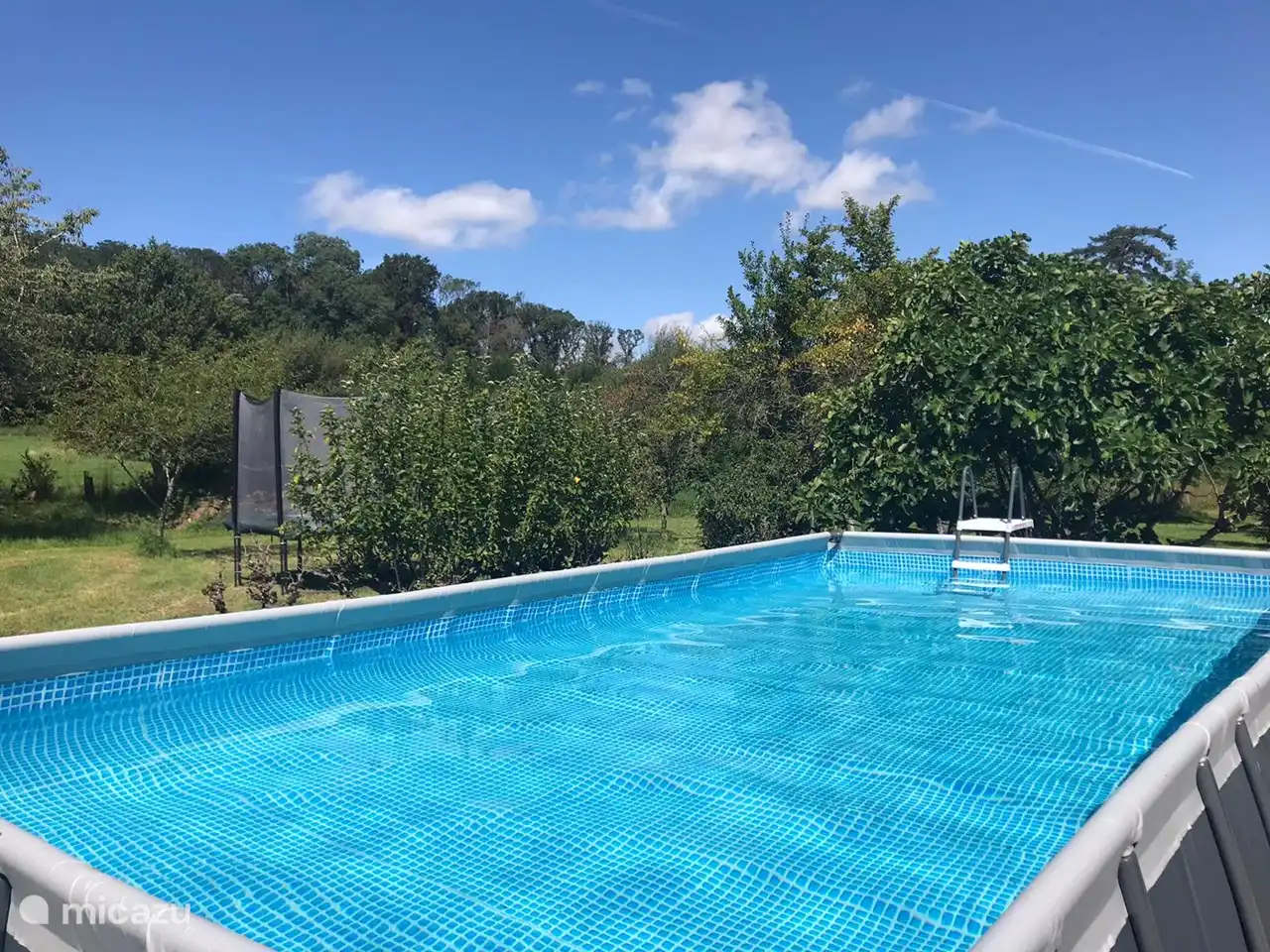 Schwimmbad und Trampolin im Hintergrund