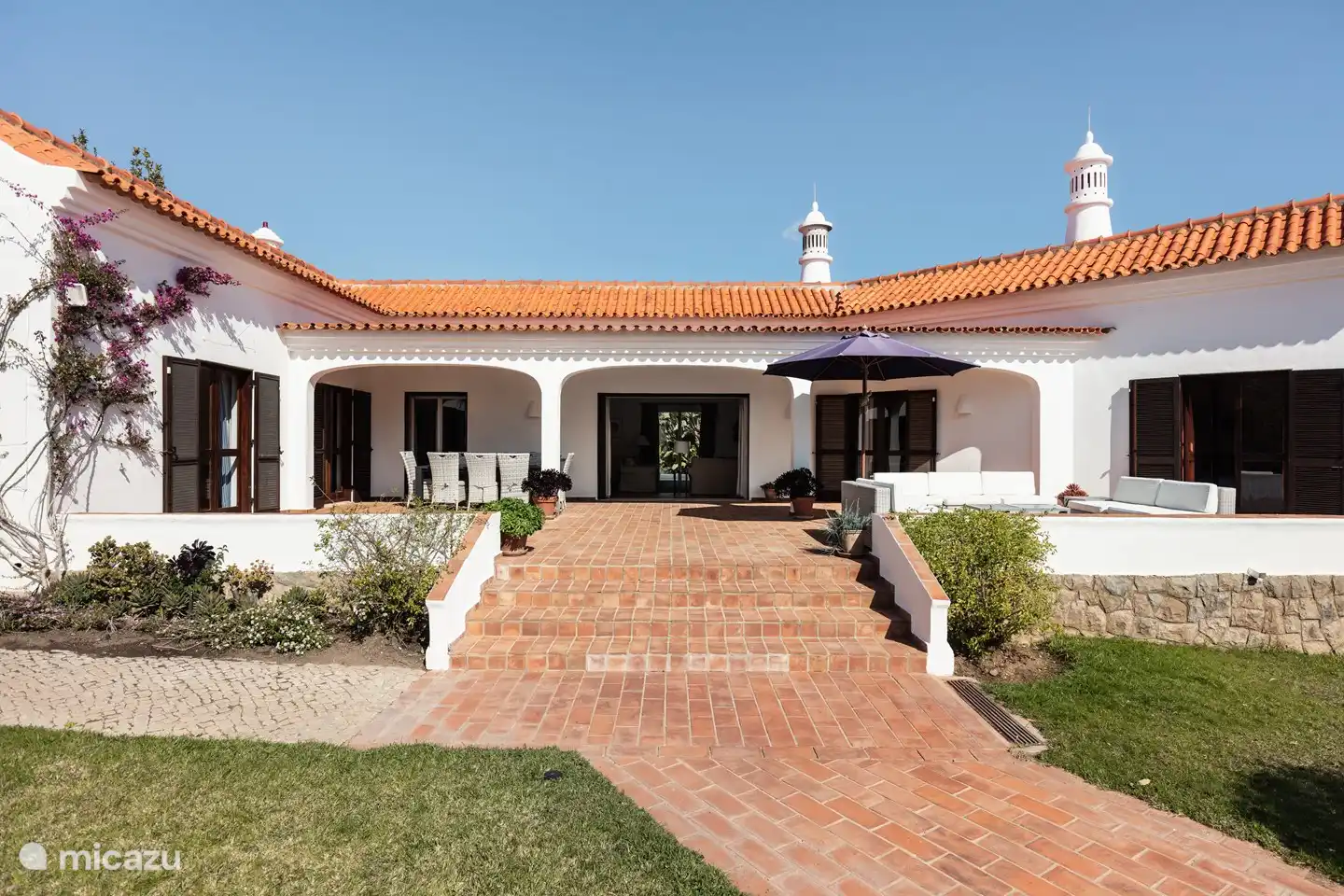 Von der Gartentreppe zur Terrasse mit der großen Schiebetür in der Mitte zum Wohnzimmer