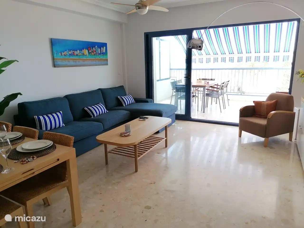 Das Wohnzimmer hat eine Schiebetür über die gesamte Breite, die vollständig geöffnet werden kann, so dass eine innen und außen eins wird.