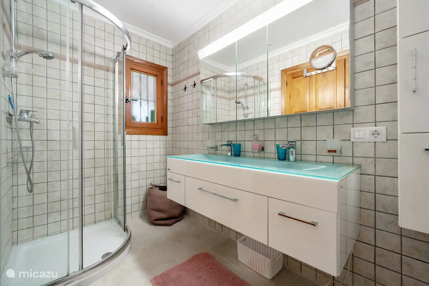 Geräumiges Bad mit Dusche und Doppelwaschbecken.