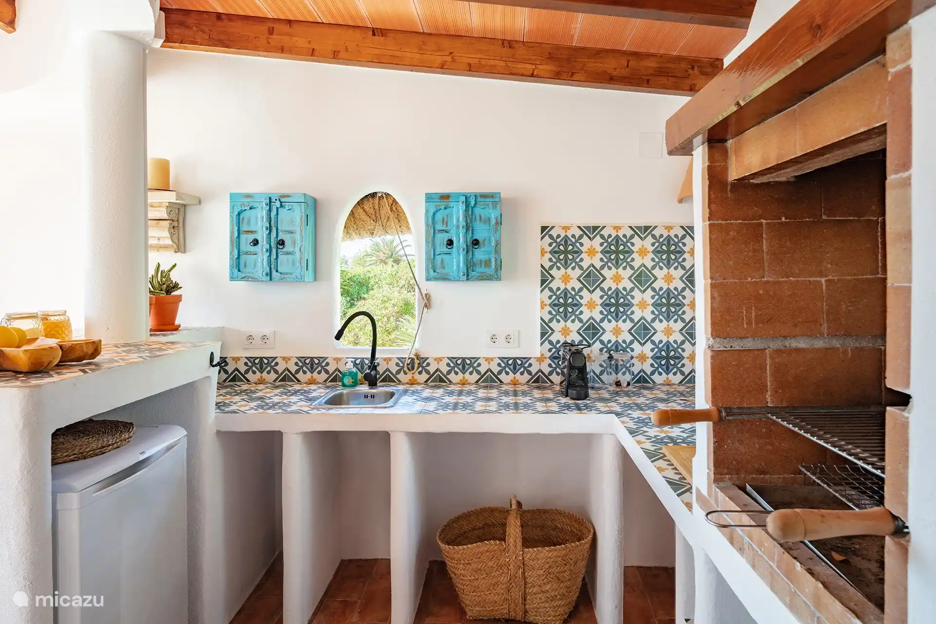 Außenküche mit Grill und Kühlschrank. 