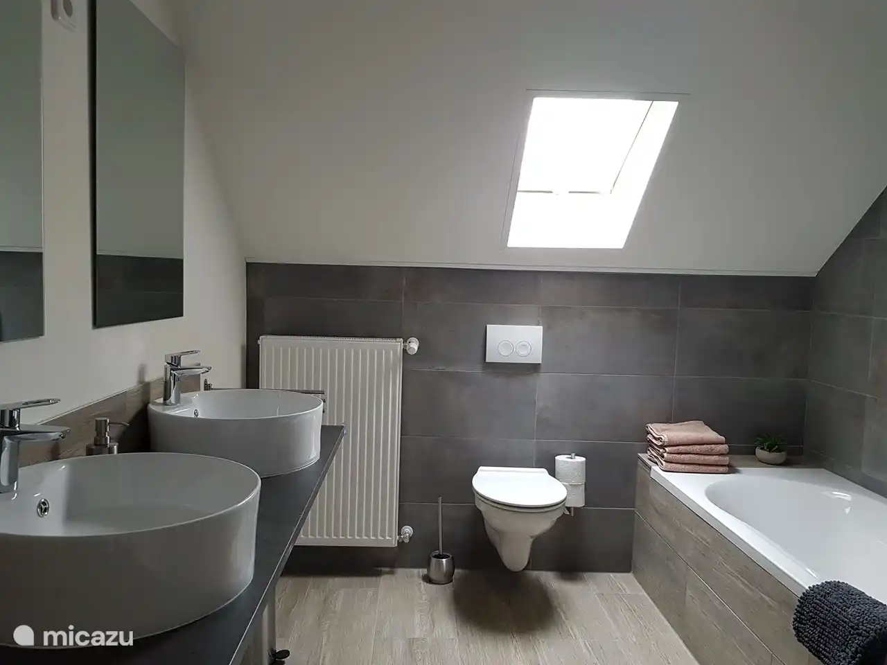 Amplio cuarto de baño con 2 lavabos, bañera, ducha y WC.