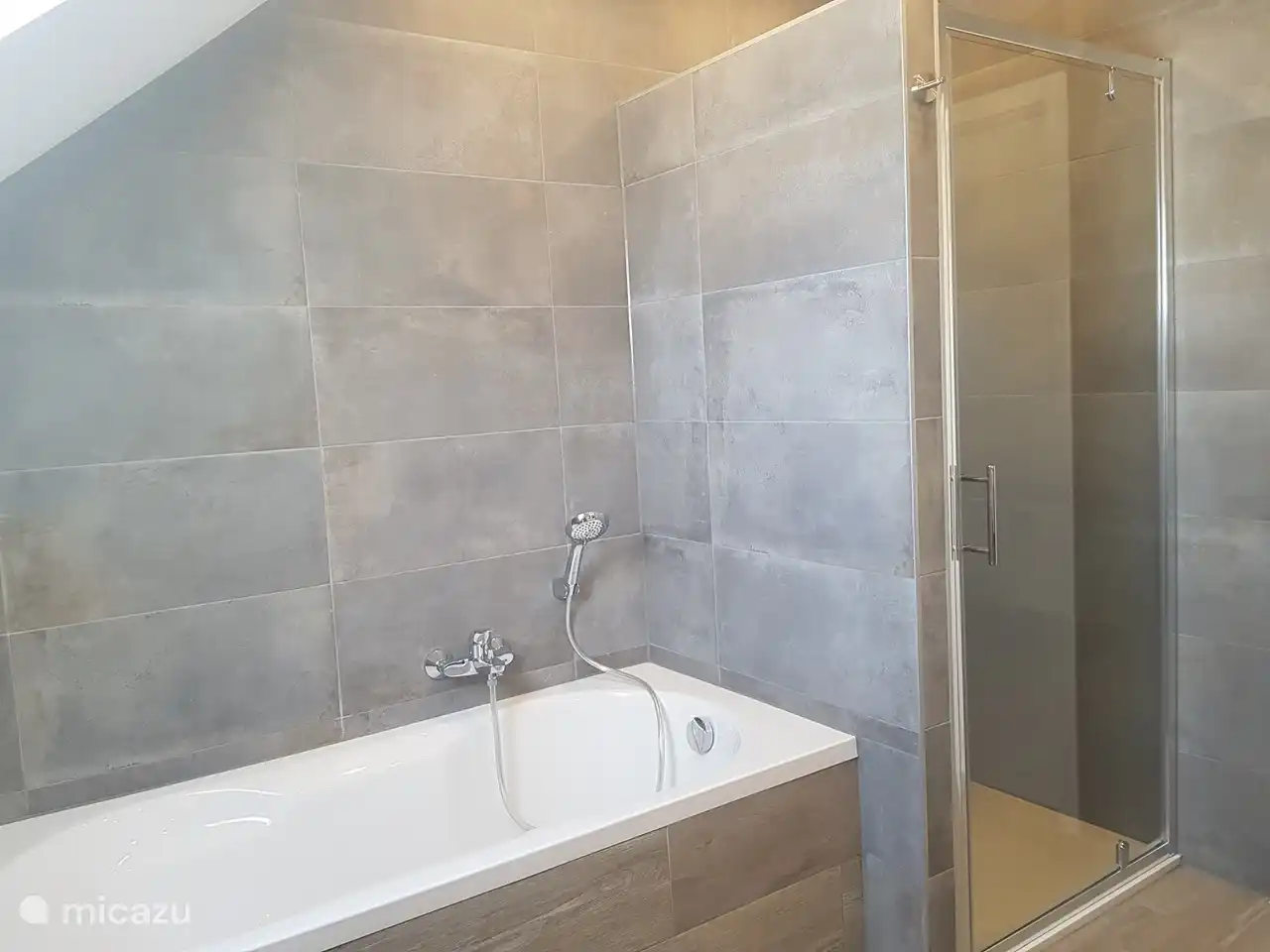 Amplio cuarto de baño con 2 lavabos, bañera, ducha y WC.