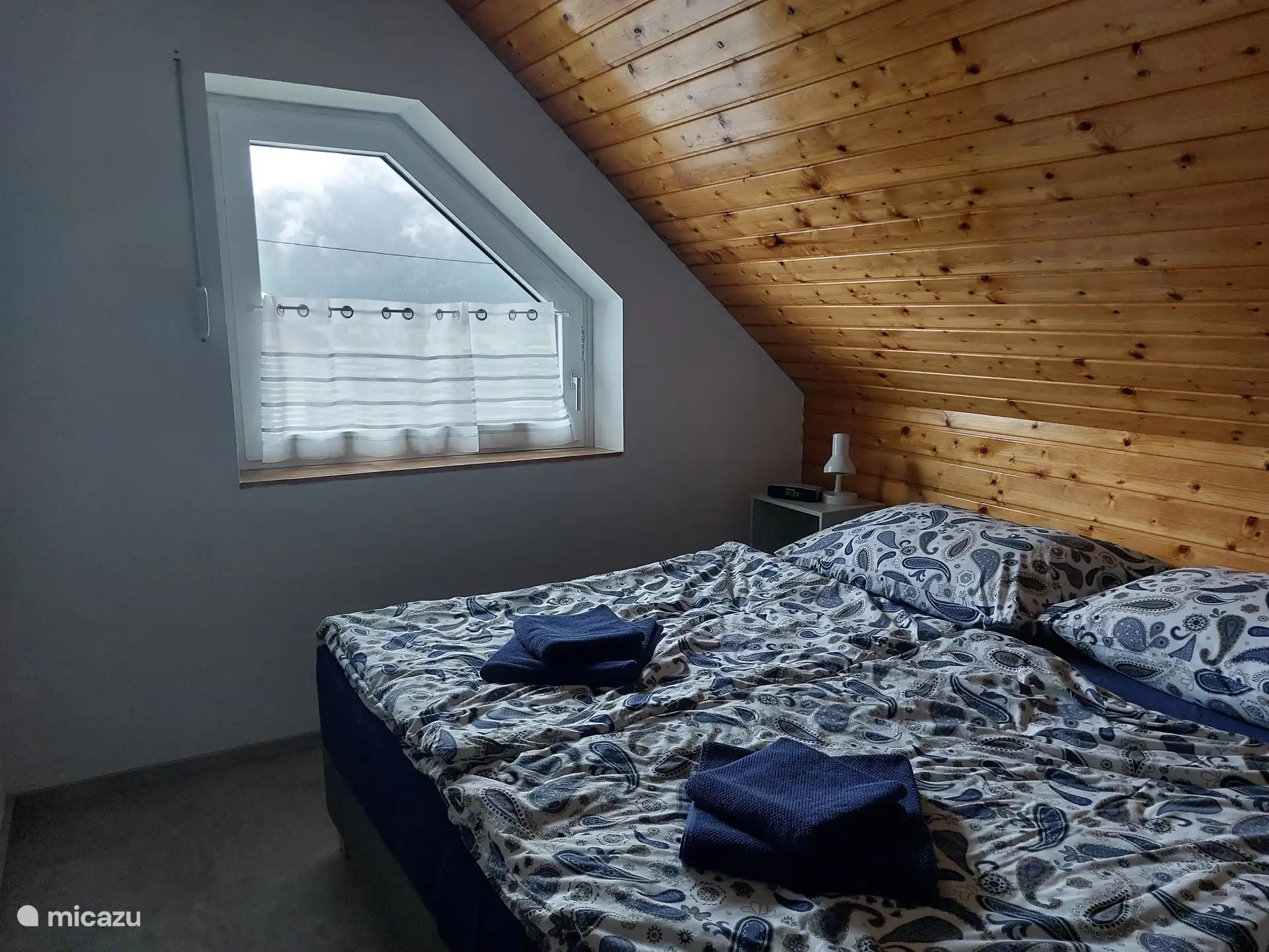 Dormitorio con cama doble grande (180x200 cm), armario y aire acondicionado. Se puede oscurecer completamente con una persiana enrollable.