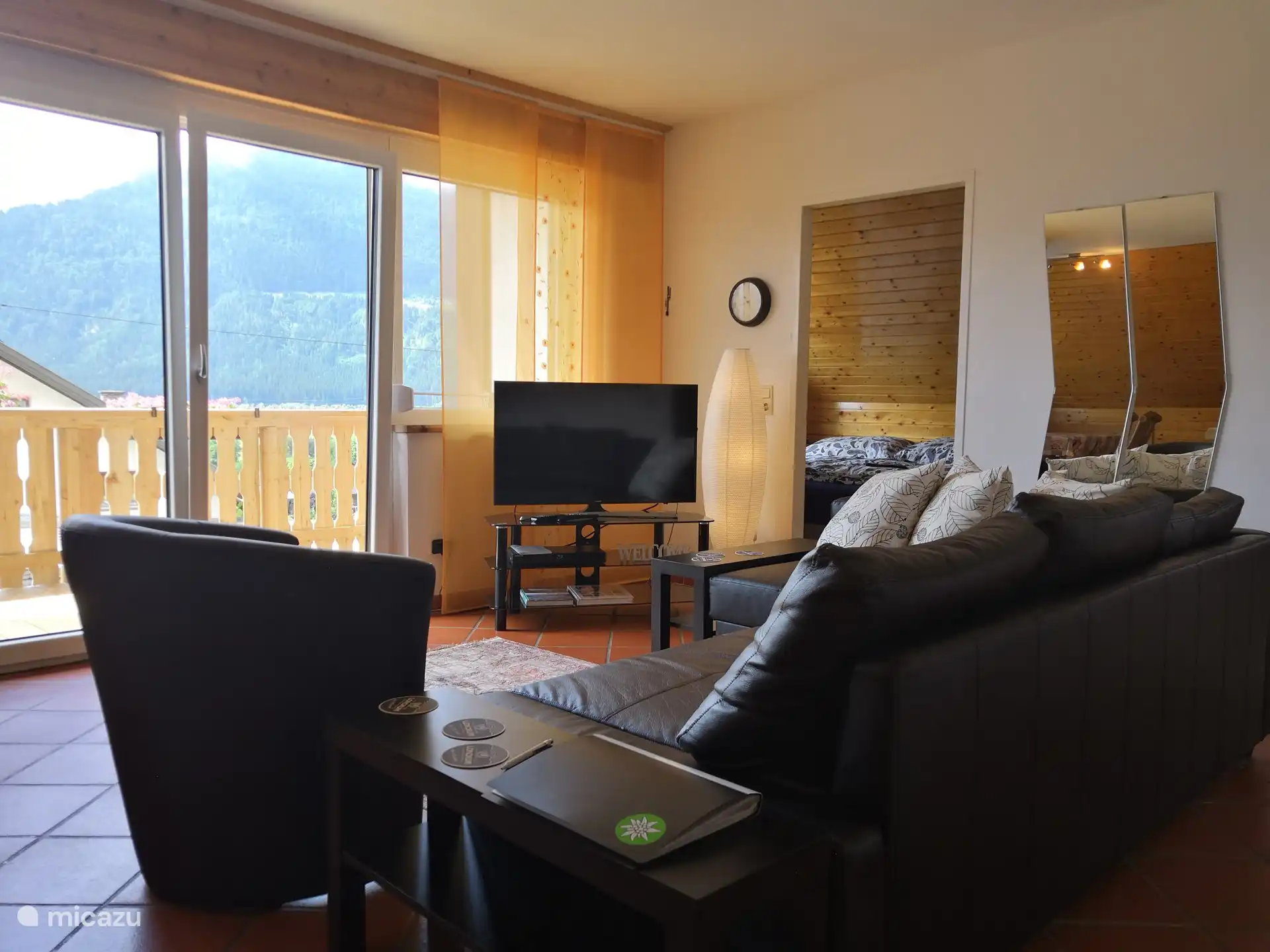 Sala de estar con vistas, sofá cama y TV con reproductor de DVD.