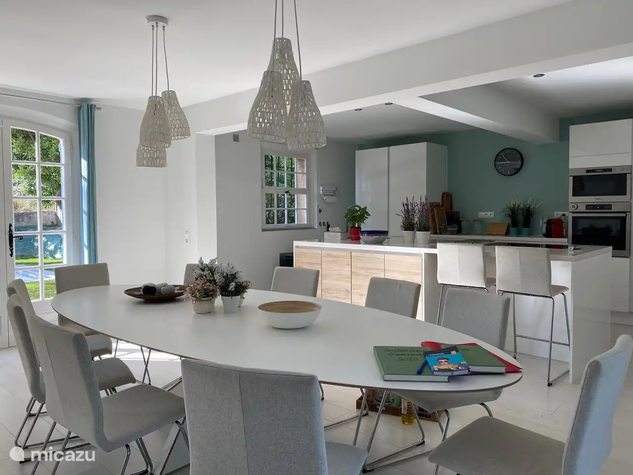 Grande table ovale avec 10 chaises et cuisine ouverte