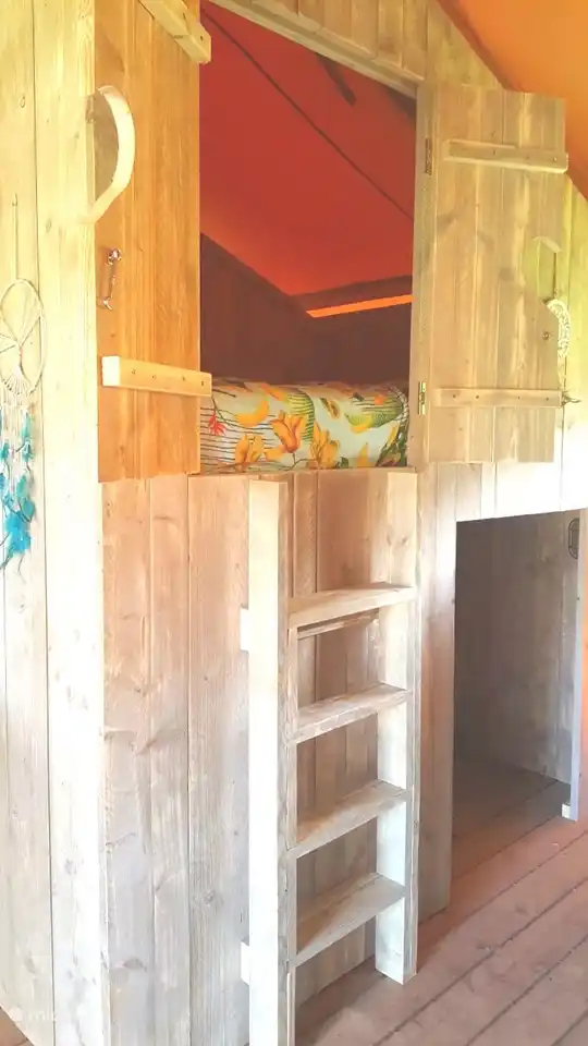 2 persoonsbedstee met eronder een speelkamer voor de kinderen