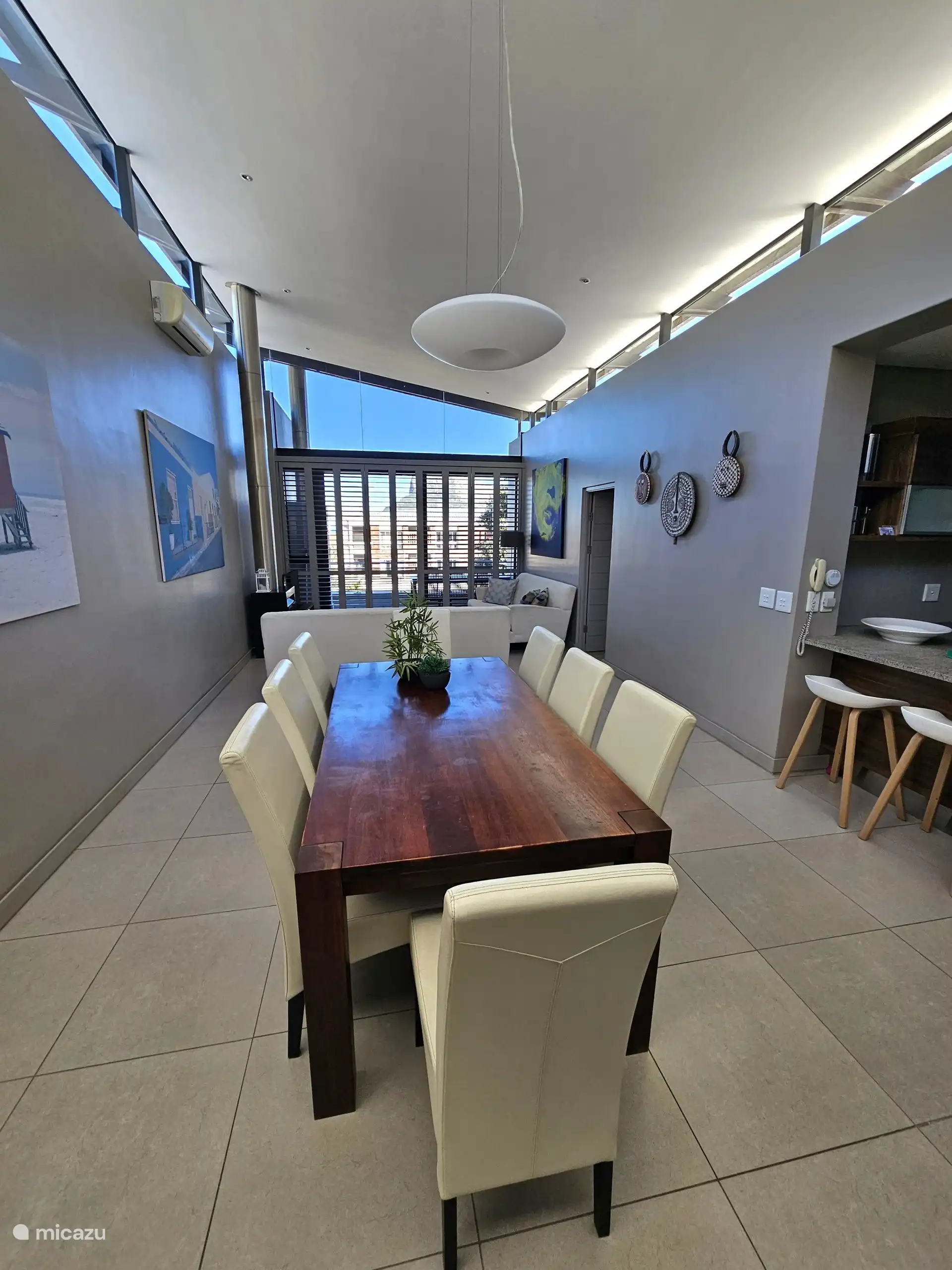 Salón de planta abierta, comedor, cocina con ventanas superiores por todas partes para una luz preciosa
