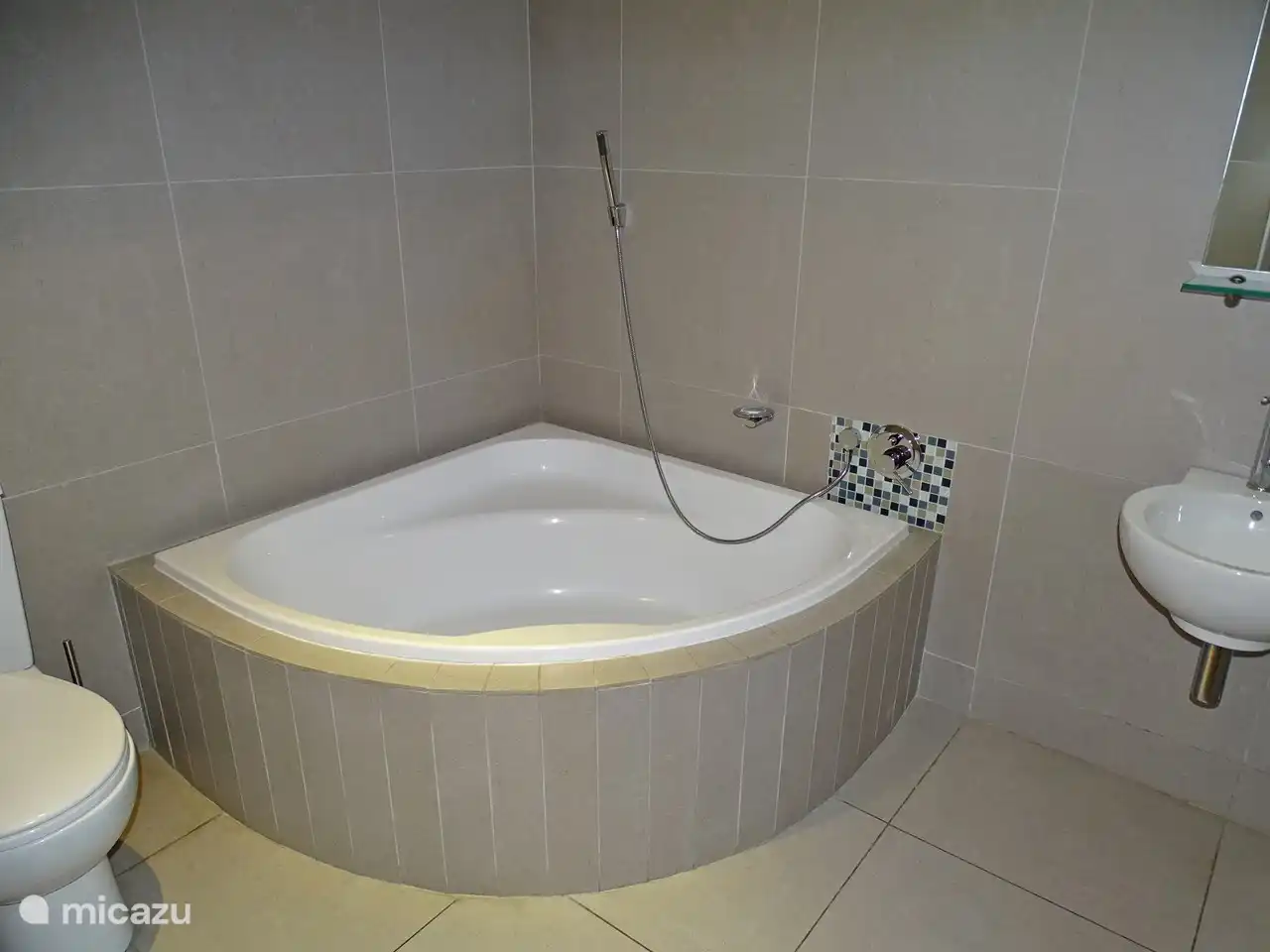 Badezimmer neben dem 2. Schlafzimmer mit Eckbadewanne, Handbrause, Toilette und Waschbecken