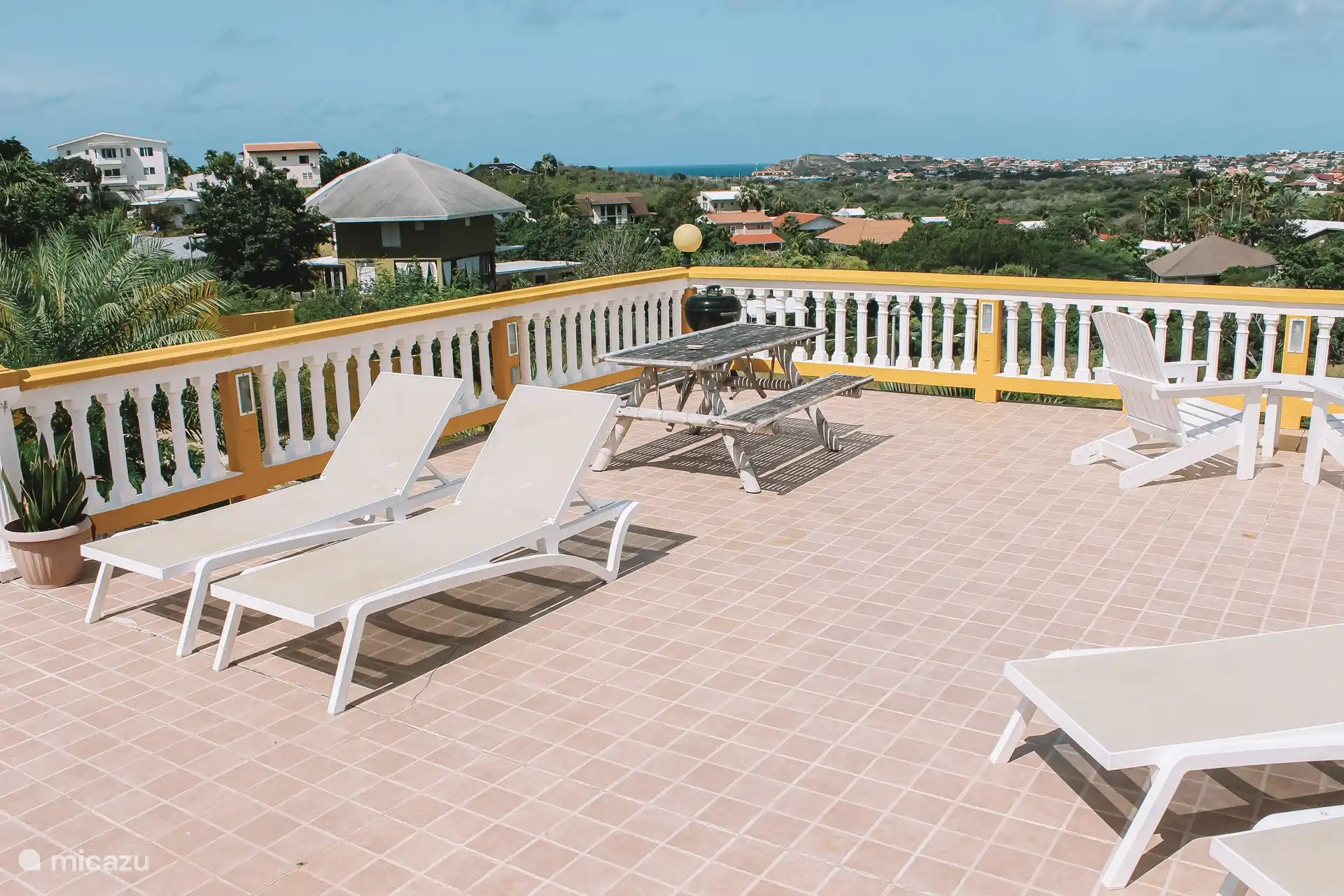 La terrasse commune avec BBQ et divers salons/coins salons.