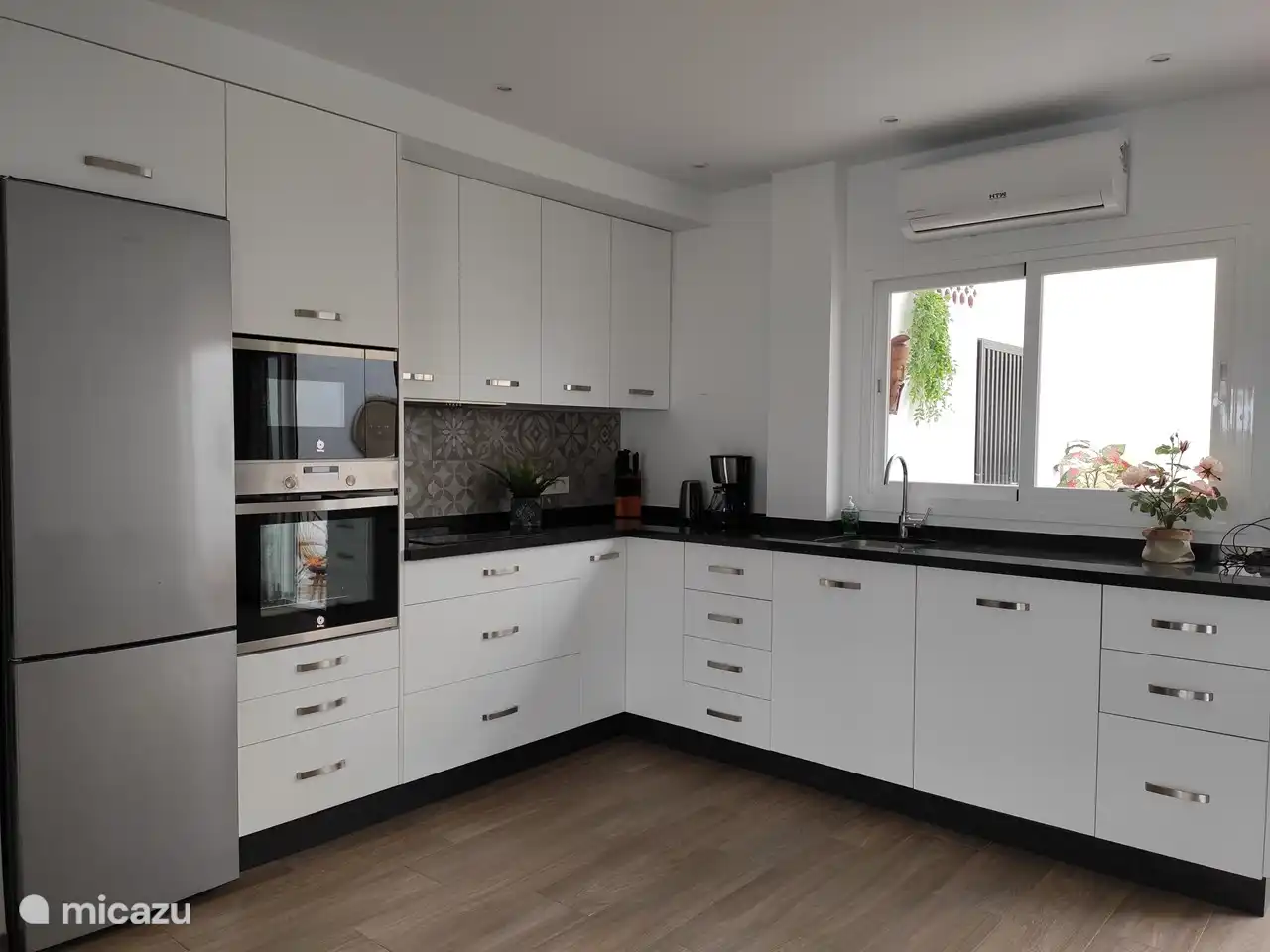 Küche mit Geschirrspüler, Backofen, Mikrowelle, Kühlschrank und Gefrierschrank.