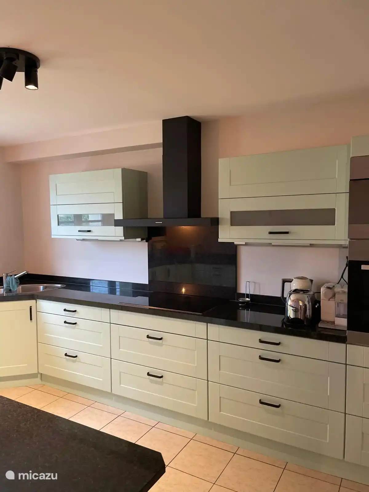 Die Küche verfügt über ein Induktionskochfeld, einen Backofen, eine Nespresso-Kaffeemaschine, einen Wasserkocher und einen Kühlschrank mit Gefrierfach.