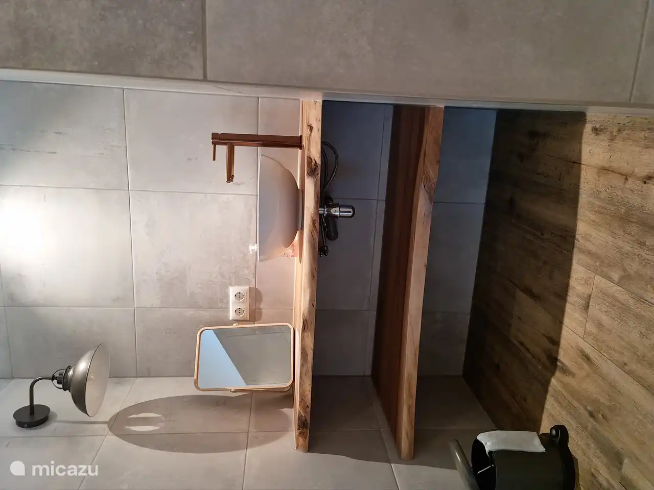 Badezimmer mit Regendusche und Waschbecken.