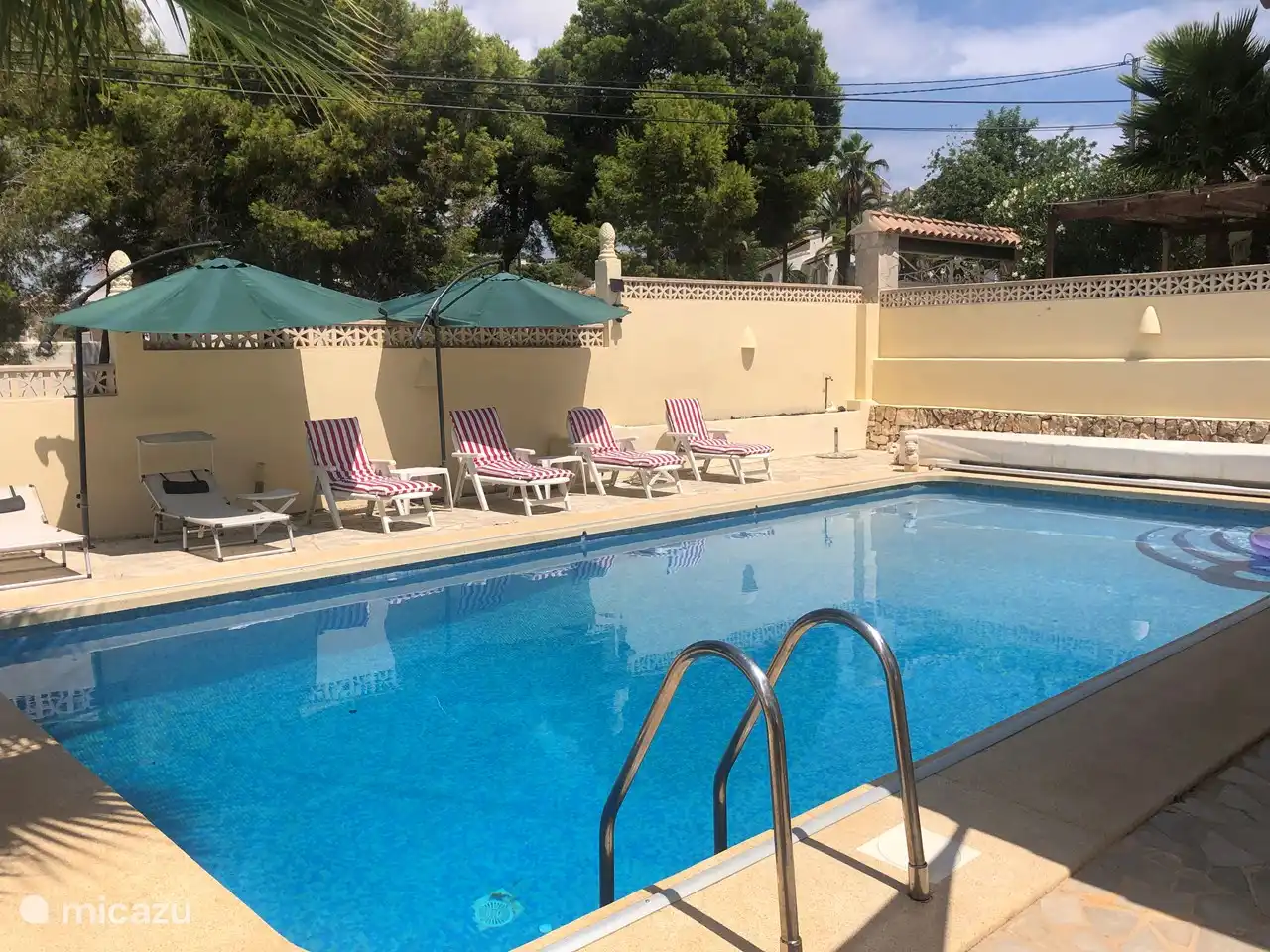 Piscine avec beaucoup de transats et ombre de divers parasols