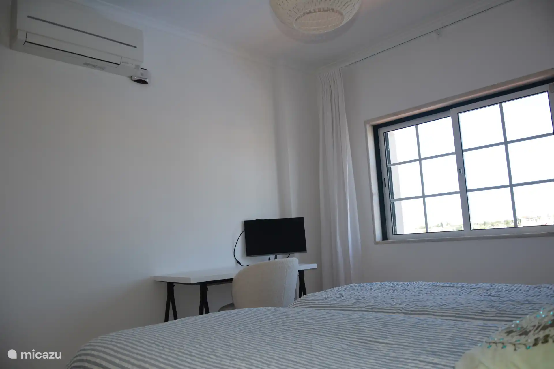 tweede slaapkamer heeft ook een bureau en monitor voor hybride werken