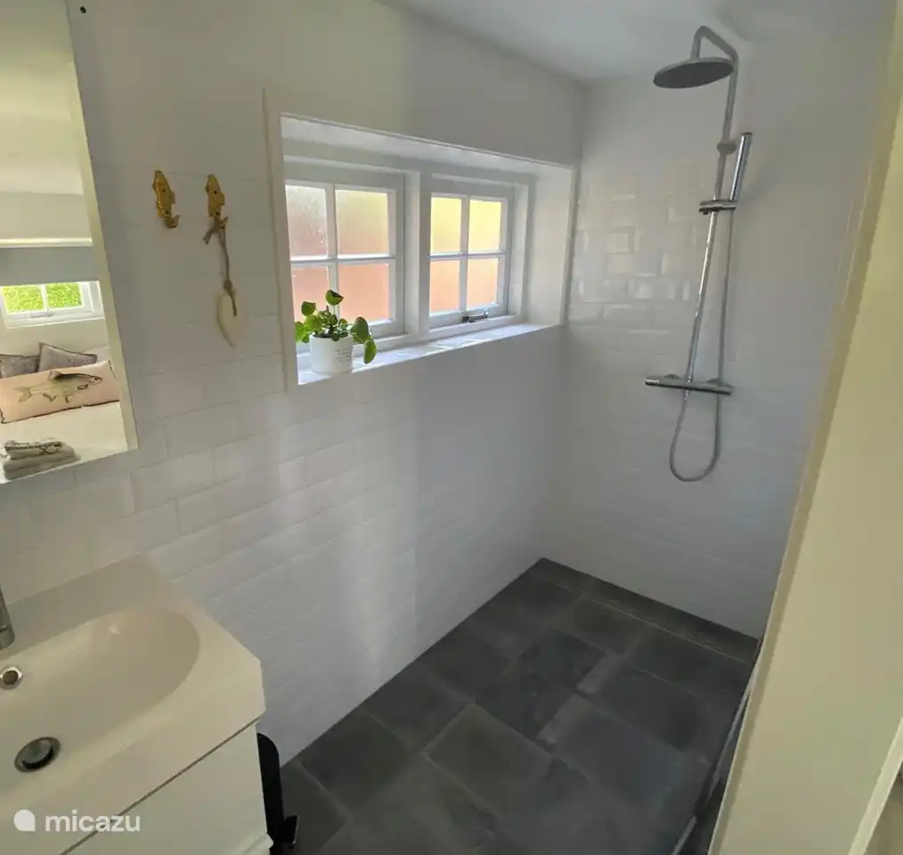 Ein separates Duschbad mit Waschbecken.