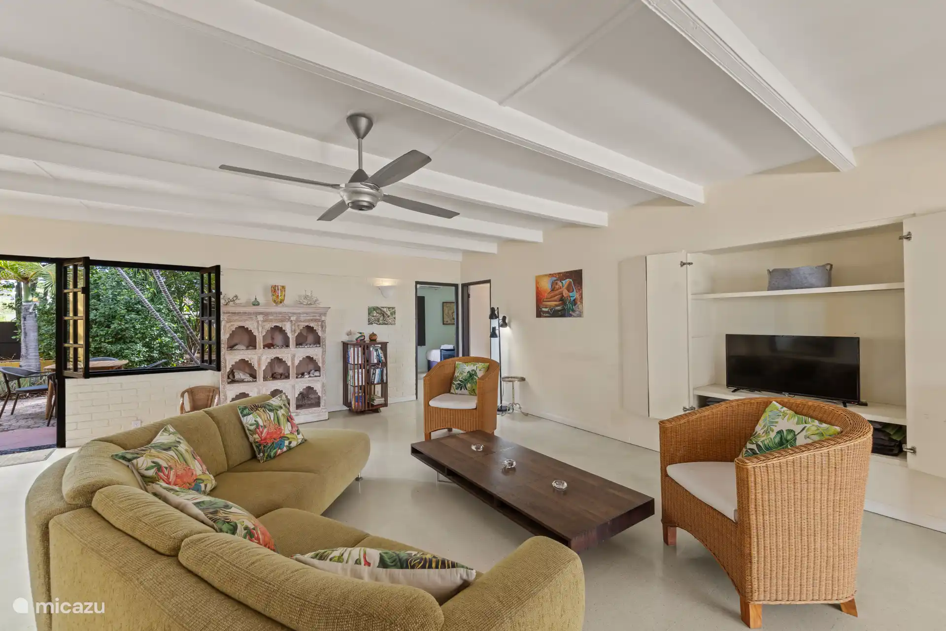 Geräumiges Wohnzimmer mit Deckenventilator, auch ein privater Arbeitsplatz vorhanden.