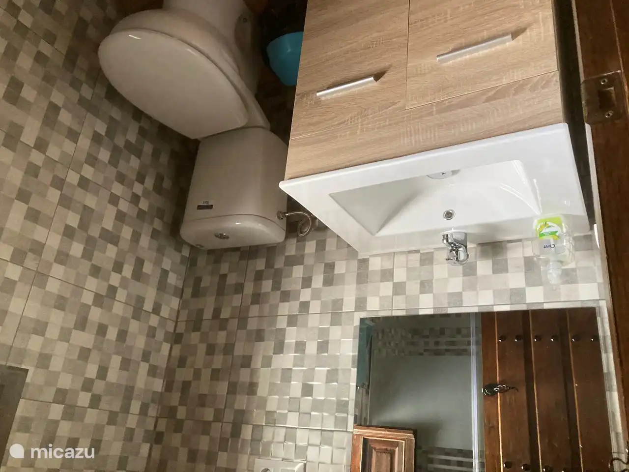 Badezimmer mit Waschbecken, geräumiger Dusche und WC.