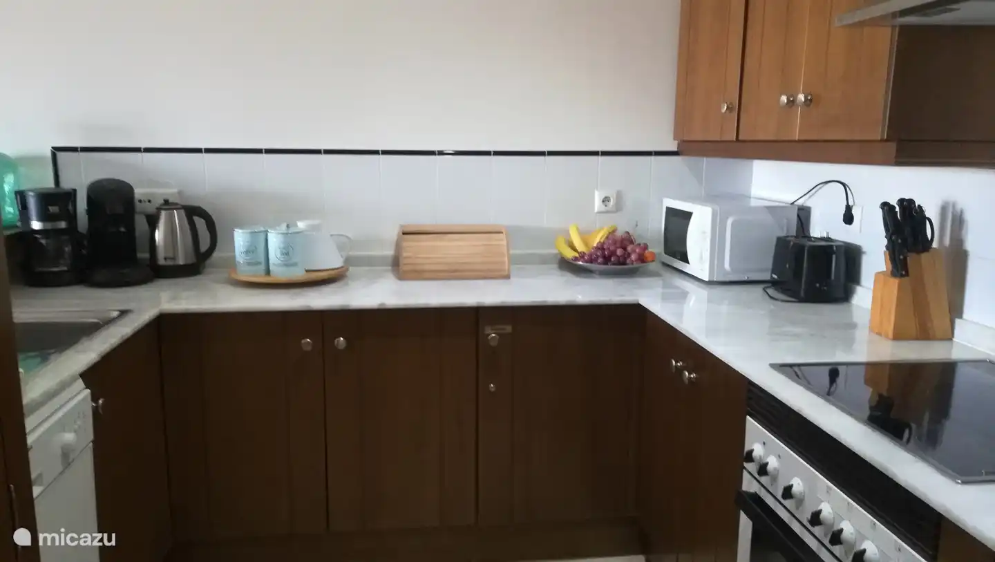 Kitchen with various equipment. Including Senseo, filter coffee maker, kettle, microwave, dishwasher.