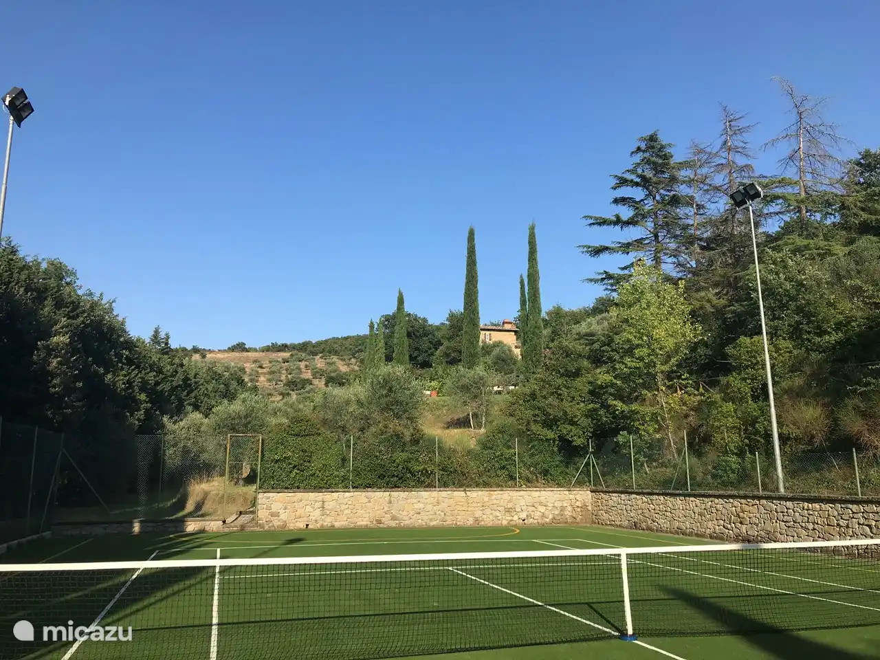 Zicht op het huis vanaf de tennisbaan