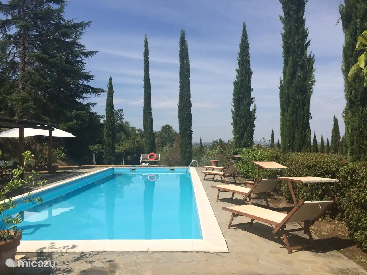 Zwembad met parasols en zonbedden