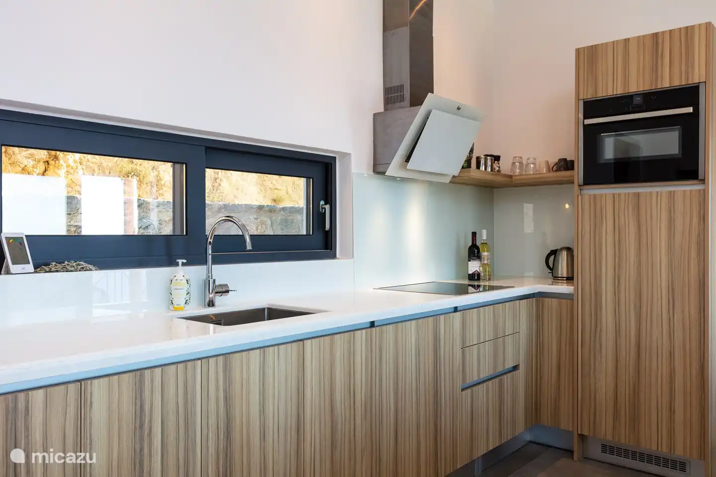 Die Küche verfügt über eine Waschmaschine, einen Geschirrspüler, einen Kombibackofen, einen großen Kühlschrank, ein Induktionskochfeld, einen Dunstabzug und eine luxuriöse Nespresso-Kaffeemaschine.