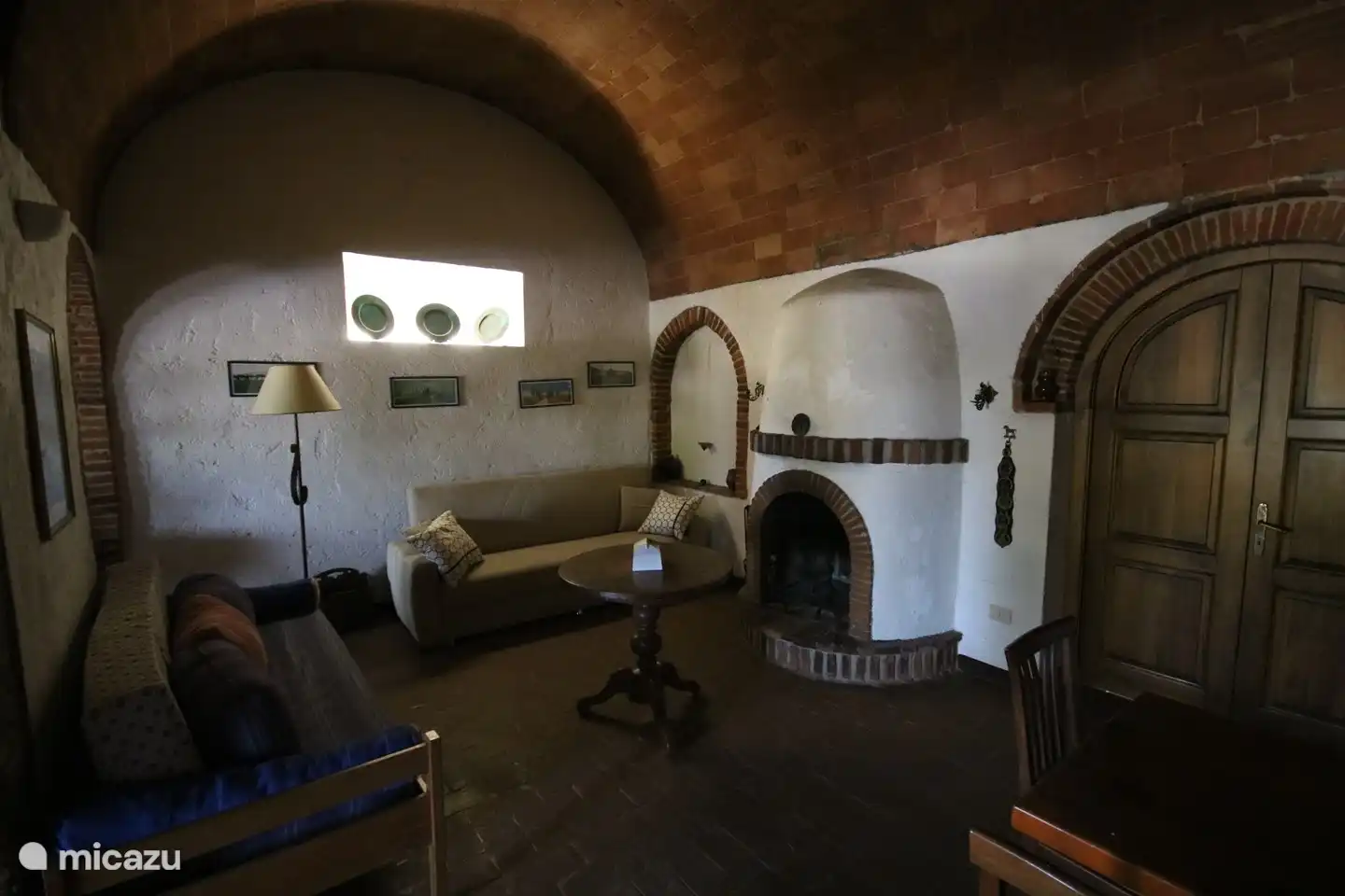 De zithoek rondom de open haard met 2 sofa's (slaapbanken).