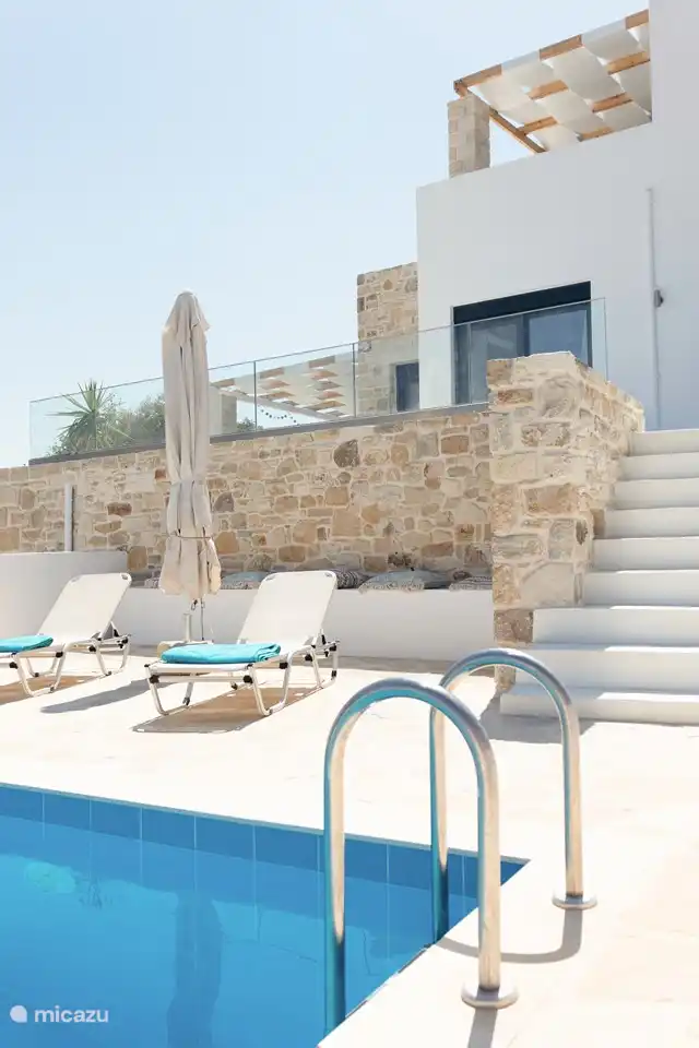 Terras bij het zwembad met ligbedden