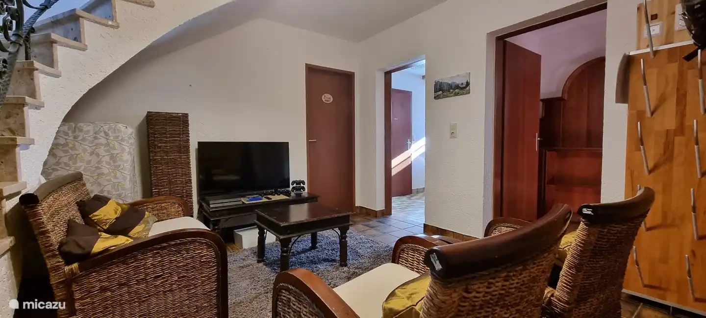 Sitting area in hall basement with TV, PlayStaion 4 and games