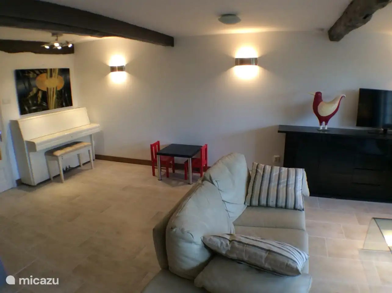 Spacious living room, with large screen smart TV, piano, bookcases, etc.