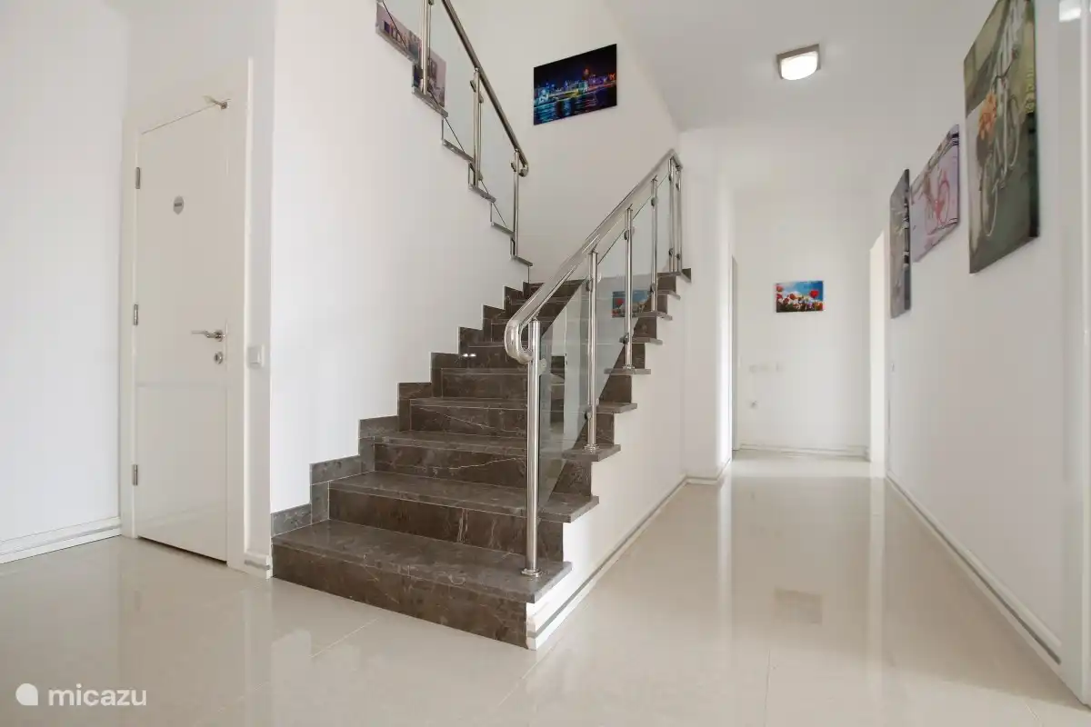 Modernes Treppenhaus in der Villa. Angrenzend an diesen Flur befinden sich die 3 Schlafzimmer, das separate Badezimmer und der Flur zur Sauna