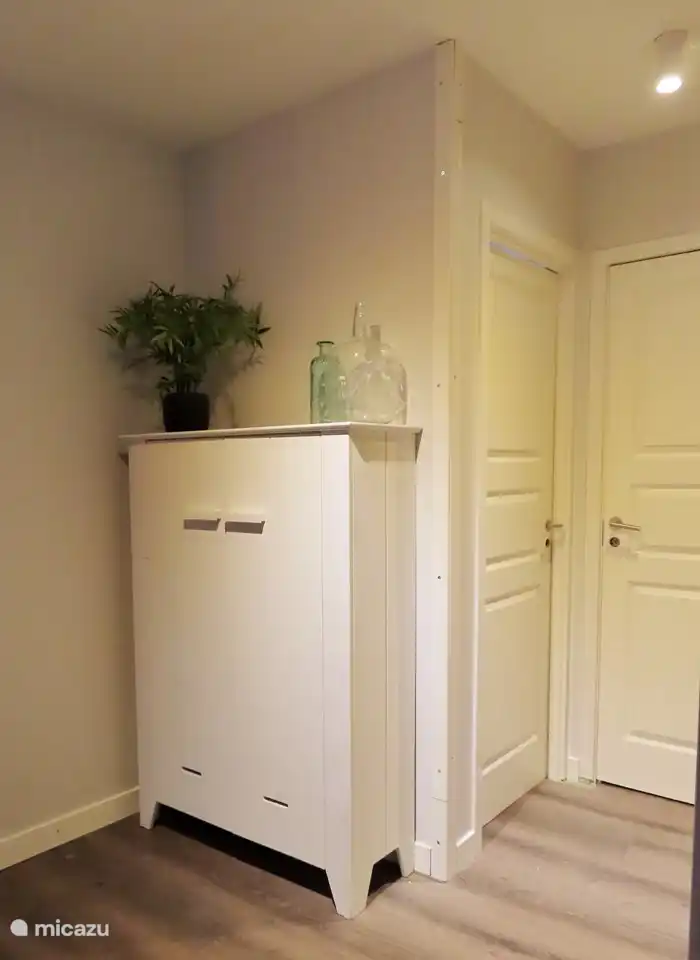 Ein Flur, gefolgt von der offenen Küche und dem Wohnzimmer und den Türen zu den Schlafzimmern und dem Badezimmer